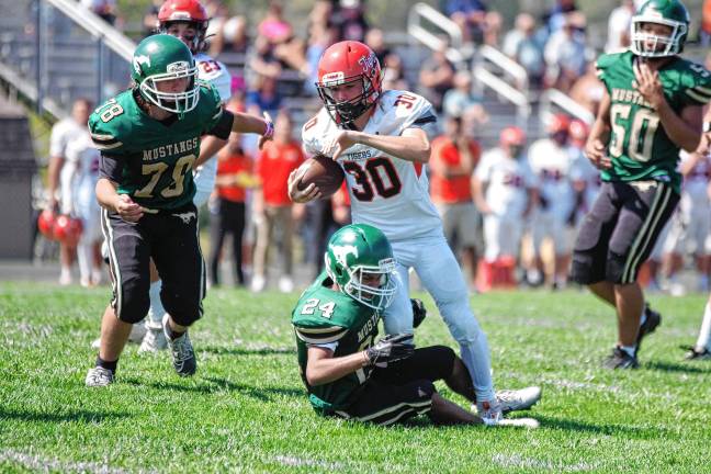 <b>Hackettstown ball carrier Carter Grant is tackled by Sussex Tech defender Anthony Caroleo in their game Saturday, Sept. 13. The Mustangs lost, 51-0, at home.</b>