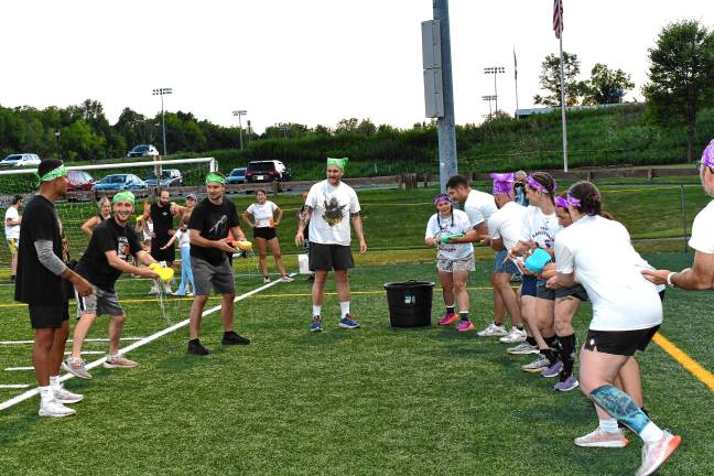 <b>Participants pass wet sponges in a Bucket Brigade competition at an Adult Field Day on Aug. 22 in Vernon. </b>