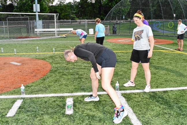 <b>Competitors try to knock down water bottles using a ball in pantyhose pulled over their heads.</b>