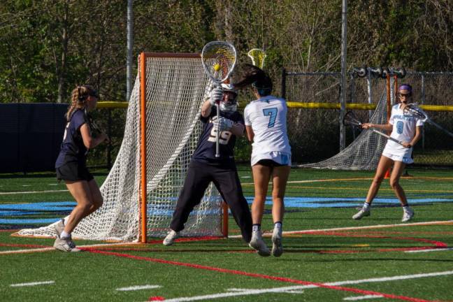 VLX2 Vernon goaltender Abby Sokolewicz (99) defends an attempted goal by Spartan midfielder Uma Kowalski (7). Riley Lewicki of Vernon, left, and Brooke Weyant of Sparta, back right, support their teammates in the Vernon defense zone.