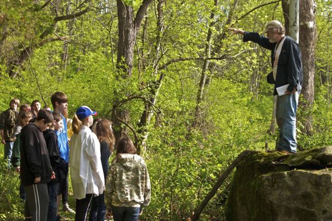 Bill Sandy, registered professional archaeologist, explains to students about how they were standing in the Indian Shop Rite and how the Indians would use what the forest provided for food, shelter and clothing.
