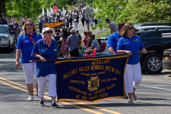 Veterans of Foreign Wars Wallkill Valley Post 8441 Auxiliary members Nancy Davis, left, and Laura Constantine carry their organization’s banner during the parade.