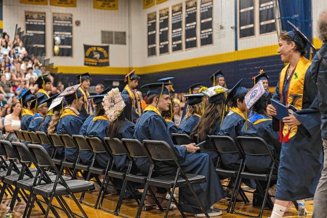 <b>Graduates collect their diplomas.</b>