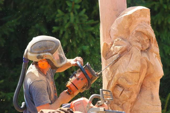 A wood-carver from Freehand Custom Carvings demonstrates skill and artistry for the gathering crowd.