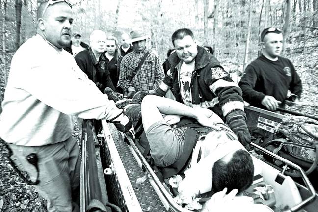 Photos by Chris Wyman As a simulated victim of a serious mountain biking accident, Jake Hasert of Barry Lakes lies in the Stokes litter rescue basket as it is slid into the back of the Vernon Police Department's Gator.
