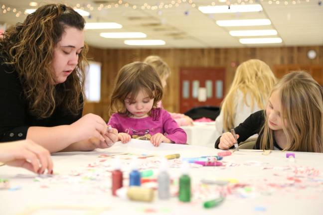 Chrystal, Kayla and Kiarra Welsh of Pa.work on a family project ornament.