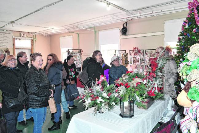 <b>Visitors peruse the tables at the Lusscroft Holiday Benefit on Saturday.</b>