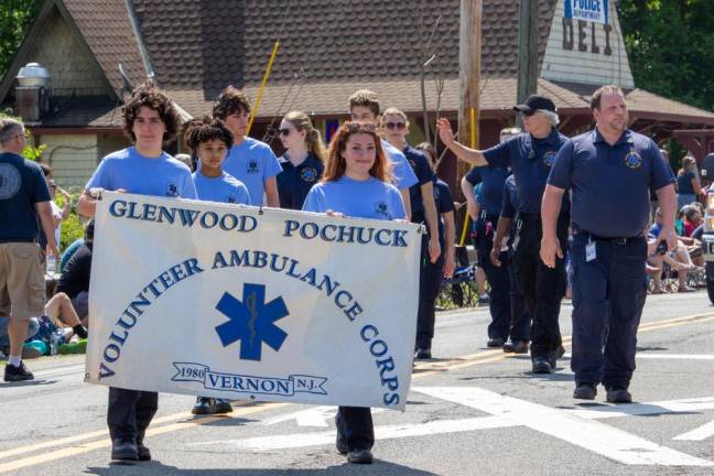 Members of the Glenwood Pochuck Volunteer Ambulance Corps walk in front of several ambulances, firetrucks and other first-responders.