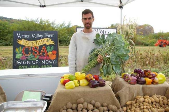 Family member Kirk Stephens of Vernon Valley Farm holds a stalk of Brussels sprouts at the Harvest Festival.