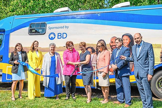 Executives from Zufall Health and lead sponsor BD cut a ribbon on the new mobile medical unit. From left are Ami Simunovich, BD chief quality &amp; regulatory officer and public affairs; Carla Burigatto, BD chief communications officer; Peg Zufall, a Zufall board member; Shana Neal, BD chief people officer; Fran Palm, Zufall president and chief executive; Annette Gonazlez, Zufall chief operating officer; David Woods, Zufall senior vice president of external affairs; and Peter Wolfson, Zufall Health Foundation board president. (Photos by April Ludwig)