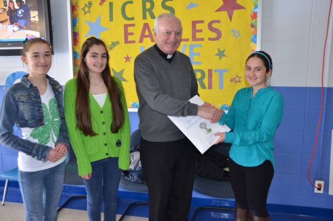 Three Student Council officers present $300 to Father William Collins of St. Jude&#x2019;s Parish, Hamburg to support Sussex County charities.