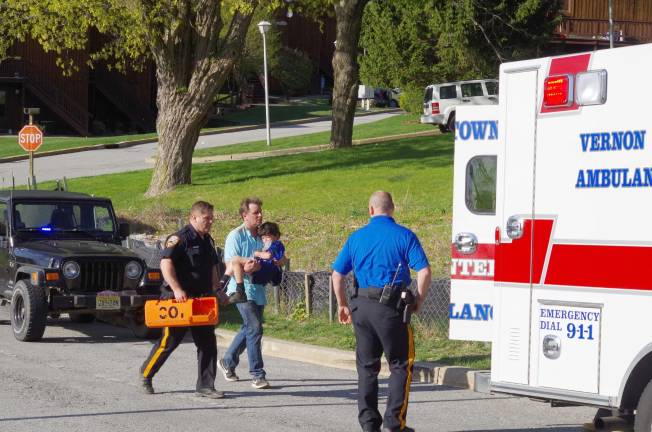 Thomas Hayes carries the six-year-old victim to an ambulance. The child was later airlifted to Morristown Medical Center.