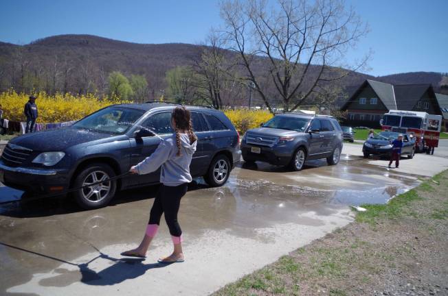 A line of vehicles including a fire truck at theVernon Girls Softball League fundraising car wash.