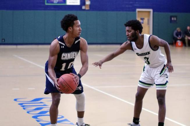 Camden County's Justin Ryder holds the ball while covered by Sussex County's Aalim Jones in the first half.