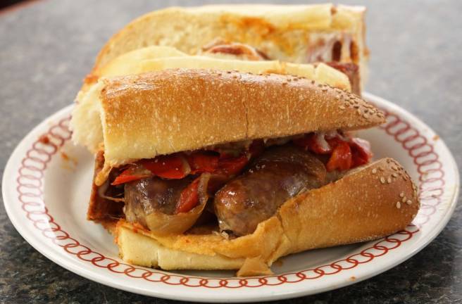 Sausage, onions, and peppers on semolina bread waits to be eaten.