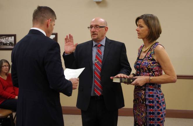 PHOTOS BY CHRIS WYMAN As his wife Cherie holds the Bible, with his right hand raised Harry Shortway is sworn in as Vernon&#xfe;&#xc4;&#xf4;s new mayor by his cousin Geoffrey Castello, an attorney and partner with Kelley Drye &amp; Warren LLP.
