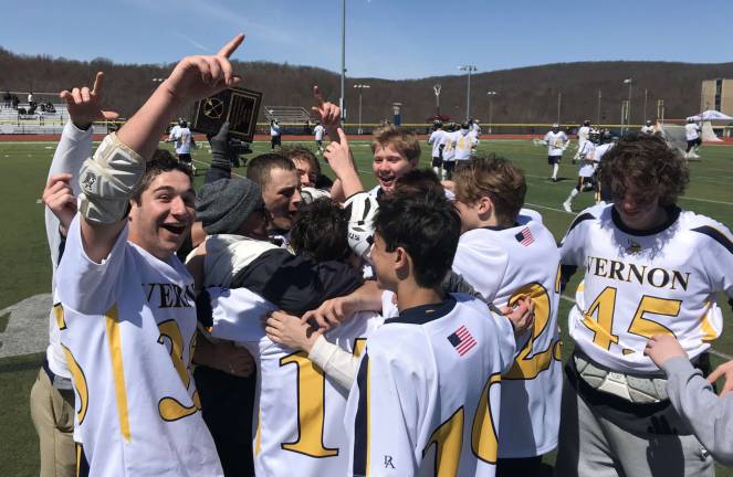 Varsity Lacrosse Players celebrate with Coach Shortway after defeating Pope John 7-3. The players presented Coach Shortway with a plaque depicting his 100th career Varsity Win from earlier in the week.