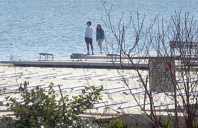 A lone couple checkS out the lake and enjoy the outdoors.