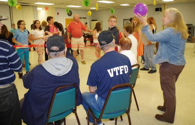 At the far right is Michele Leonard of The Center for Prevention and Counseling as she explains the exercise of tossing a ball of yarn back and forth across the circle creating a &#xfe;&#xc4;&#xfa;dream catcher&#xfe;&#xc4;&#xf9; until there were enough strands to support and keep a balloon from falling to the floor.