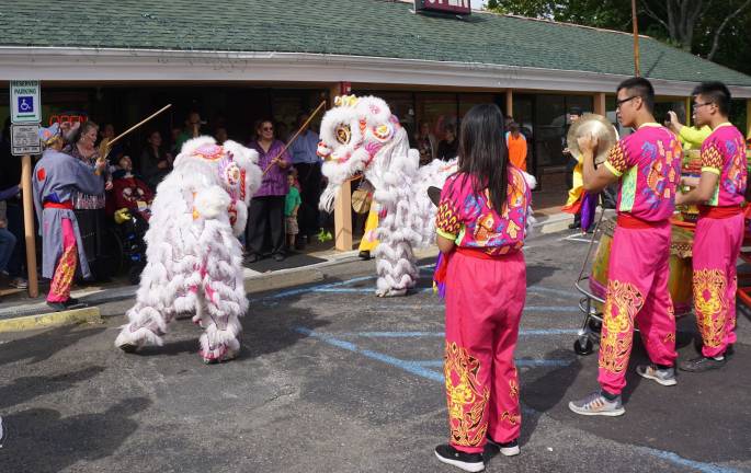 Two Chinese lions get ready to eat sushi at Wing's Asian Bistro.