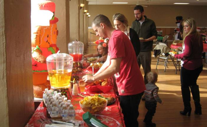 PHOTOS BY JANET REDYKE Partiers help themselves to tasty refreshments at the December 2 Christmas party held at the Barry Lakes Clubhouse.