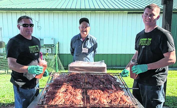 <b>Art Fetzer and sons help prepare the barbecue.</b>