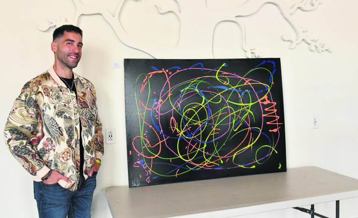 <b>Brian Cheda of Andover stands next to his painting, Pathways to Recovery.</b>