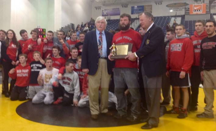 High Point wrestling coach John Gardner is presented wtih the state championship plaque after the Wildcats won the state Group 2 championship.
