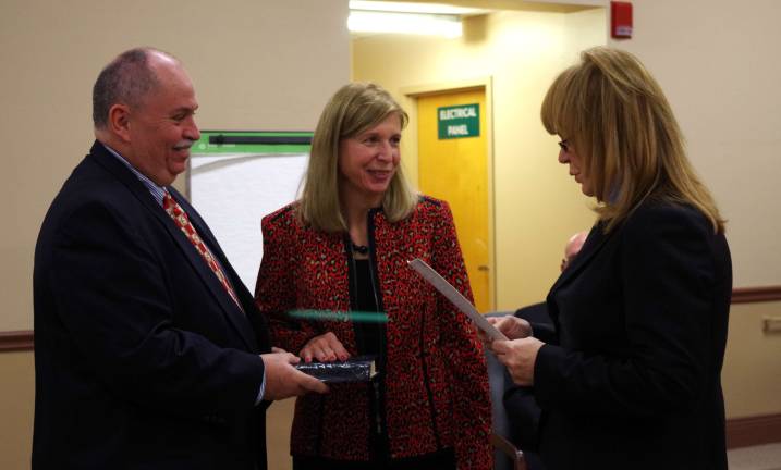 With her husband John holding the Bible, at center Councilwoman Sandra Ooms is shown being sworn into office by Assemblywoman Gale Phoebus.