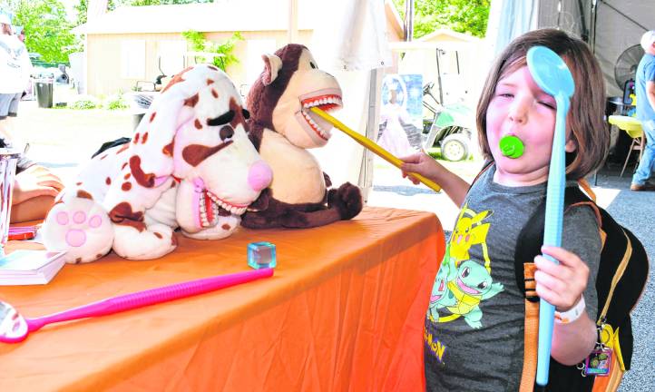 <b>Natalie Jans of Lafayette holds large toy dental equipment.</b>