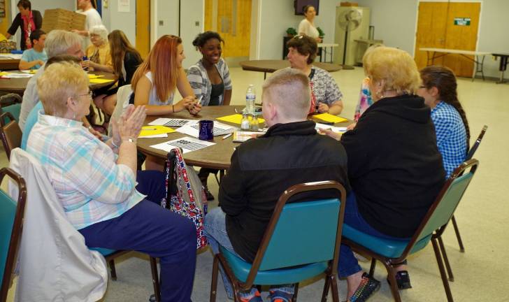 Seniors and students talk about the string exercise as they prepare for a lunch of pizza, spaghetti, meatballs, salad, and string beans.