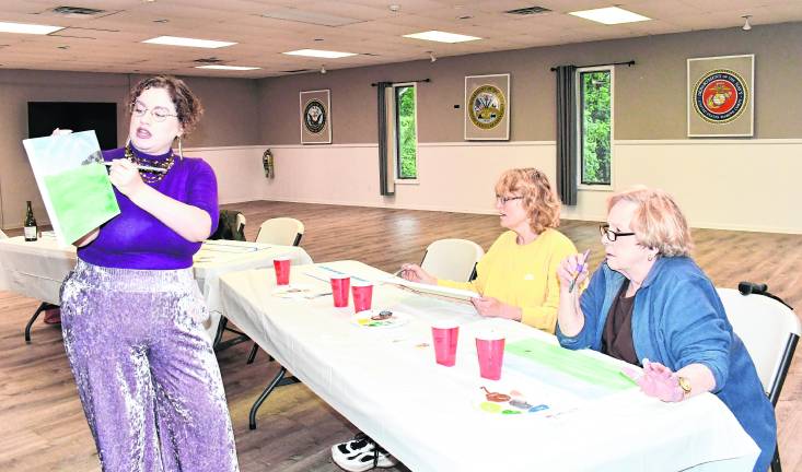 <b>Carolyn Krone holds up a painting while Nancy Grimaldi of the Vernon Historical Society and Marilyn Van Gulick of Vernon look on.</b>