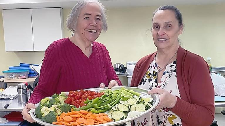 Connie Smith and Kathy McNickle have volunteered in the kitchen for the program since its inception (Photo by Laurie Gordon)