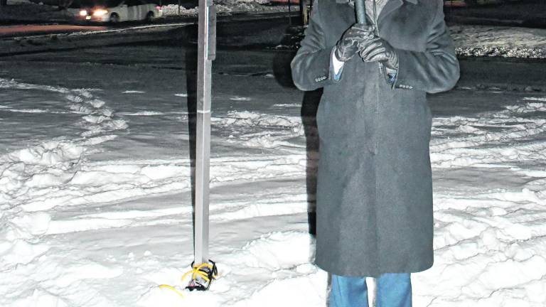 <b>Rabbi Mendel Dubov speaks in front of the Menorah.</b>