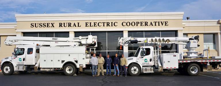 The five crewmembers are shown in front of the Sussex Rural building.
