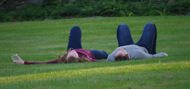 A couple relaxes in the grass at the gardens at Meadowburn Farm.