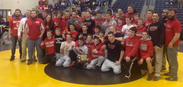 The High Point wrestling team poses with their championship plaque and trophy.