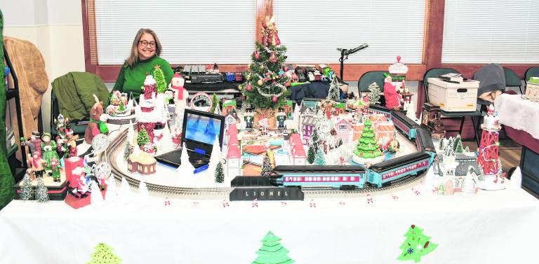 <b>Candace Special of Wantage sits behind a Lionel train display.</b>