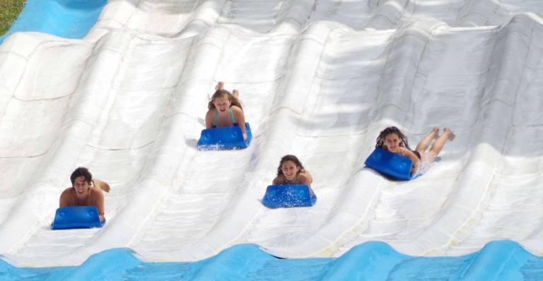 Visitors are shown coming down the rippled surface of Surf Hill.