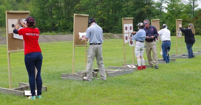 Shooters go out to change targets during a safety period on the handgun range.
