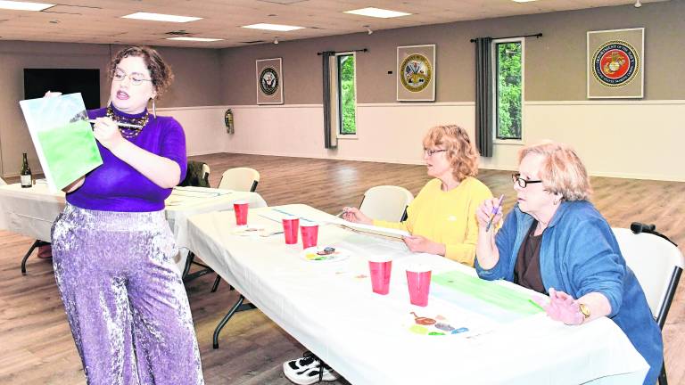 <b>Carolyn Krone holds up a painting while Nancy Grimaldi of the Vernon Historical Society and Marilyn Van Gulick of Vernon look on.</b>