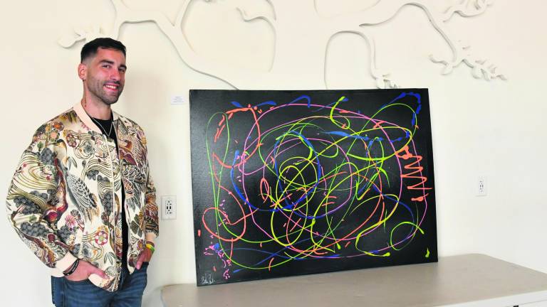 <b>Brian Cheda of Andover stands next to his painting, Pathways to Recovery.</b>