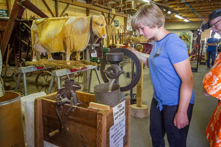 $!<b>Fair attendee uses an antique corn sheller and grinder.</b>