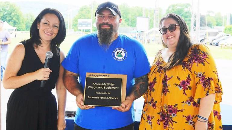 Councilman Concetto Formica (center) receives a plaque for the handicapped-accessible playground equipment, with Laura Hawkins (left) and Tamara Contreras (Photo by Vera Olinski)