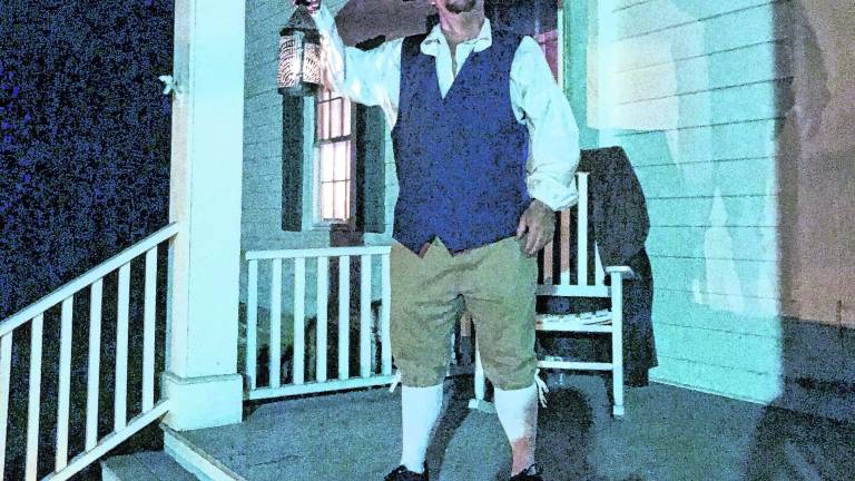 <b>A reenactor holds a lantern.</b>